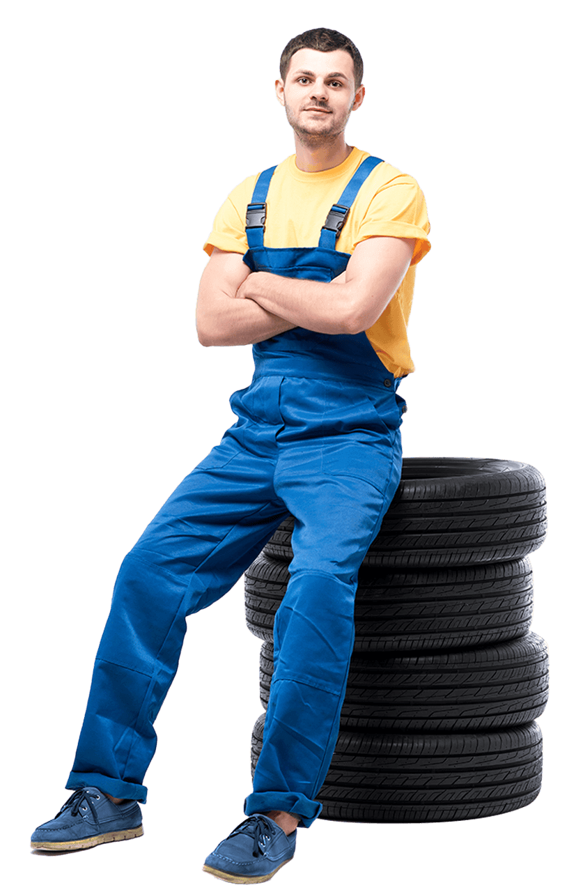 tire serviceman sitting on a pile of car tires
